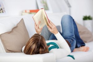 Close up of lying woman reading book relaxing at home